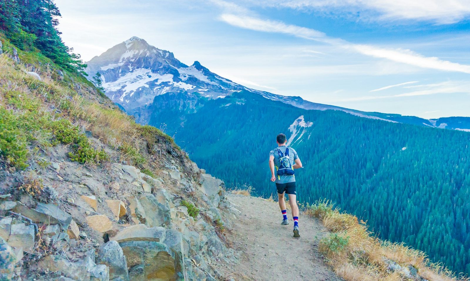 A man running on a path near a mountain