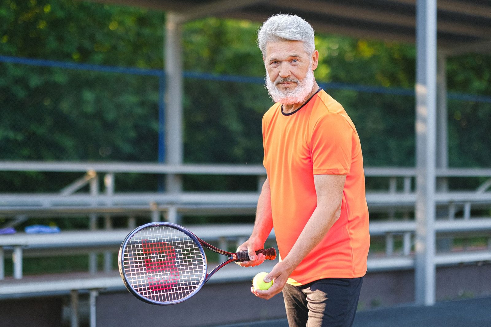 A senior player preparing to hit the ball during tennis training