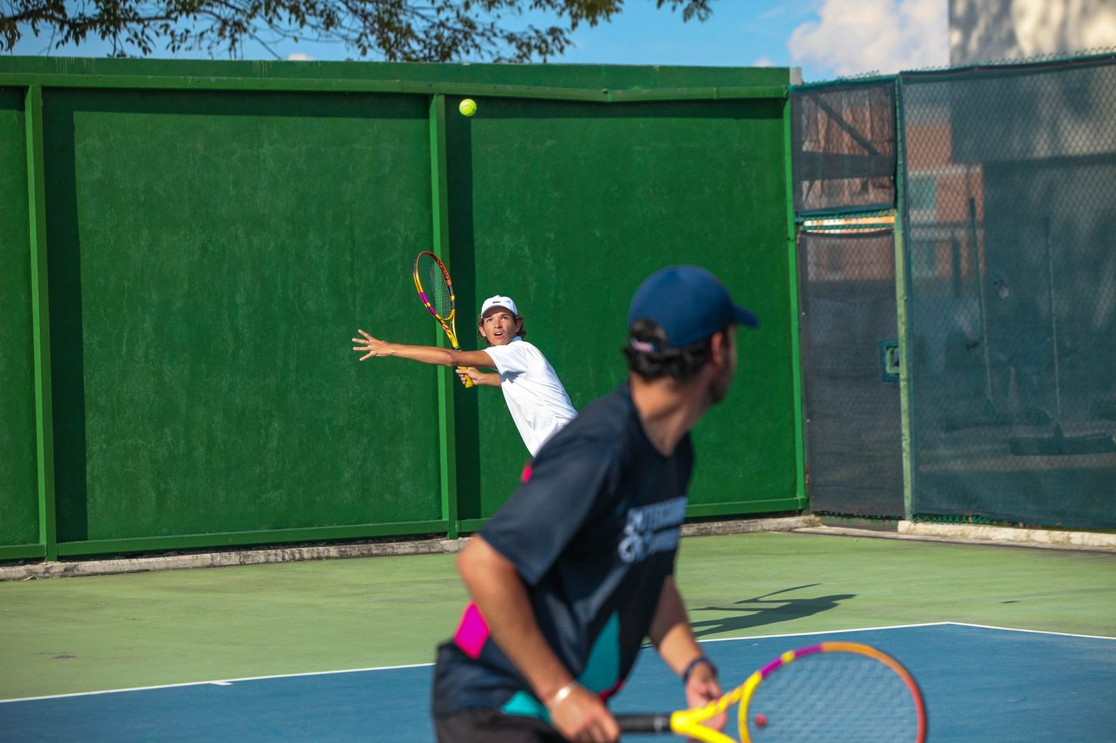 Athletes competing in a tennis match outdoors