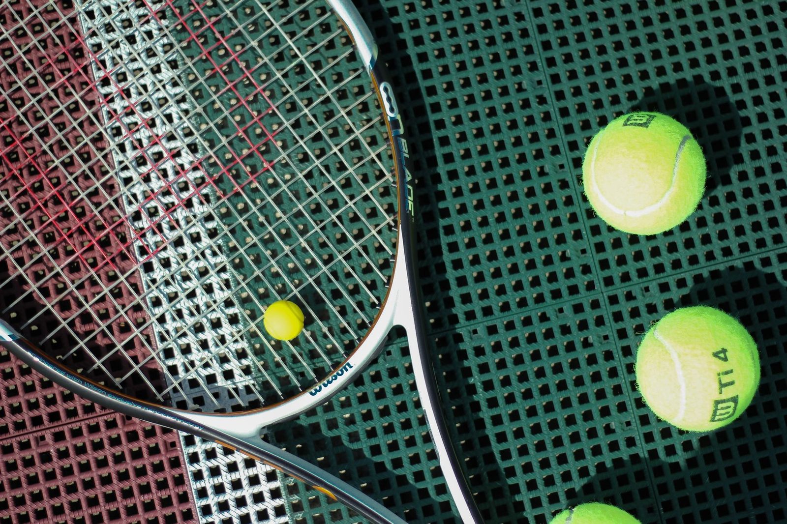 Top-down view of a tennis racquet and balls on a court