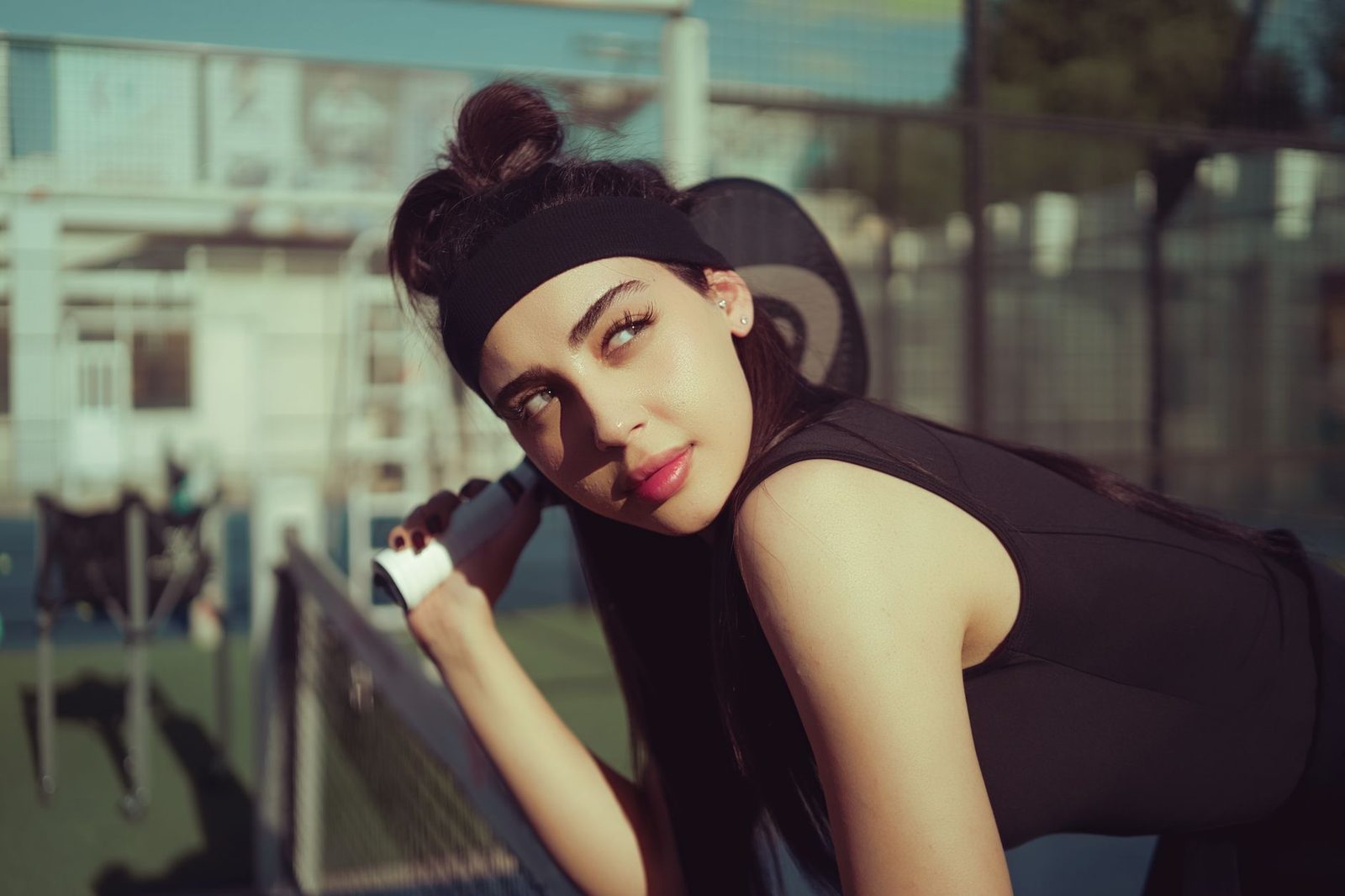 A young woman preparing for a point on an outdoor tennis court