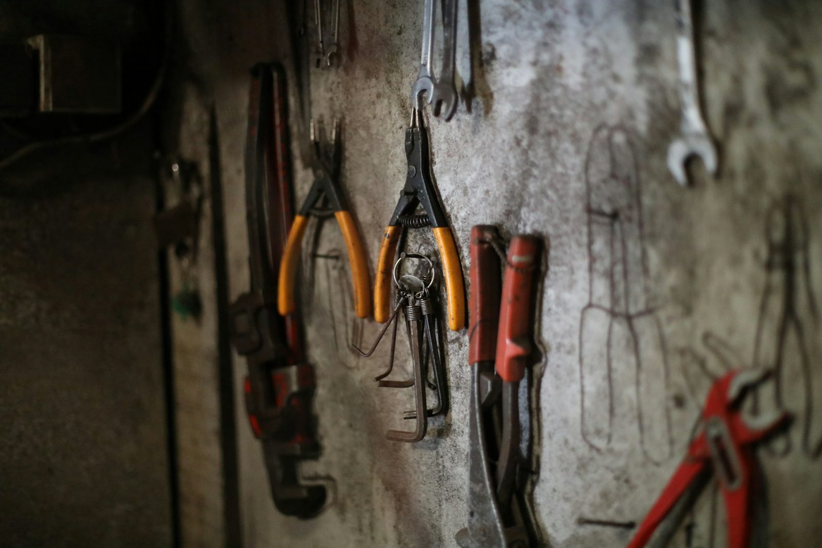 Assorted hand tools hanging in order on a workshop wall
