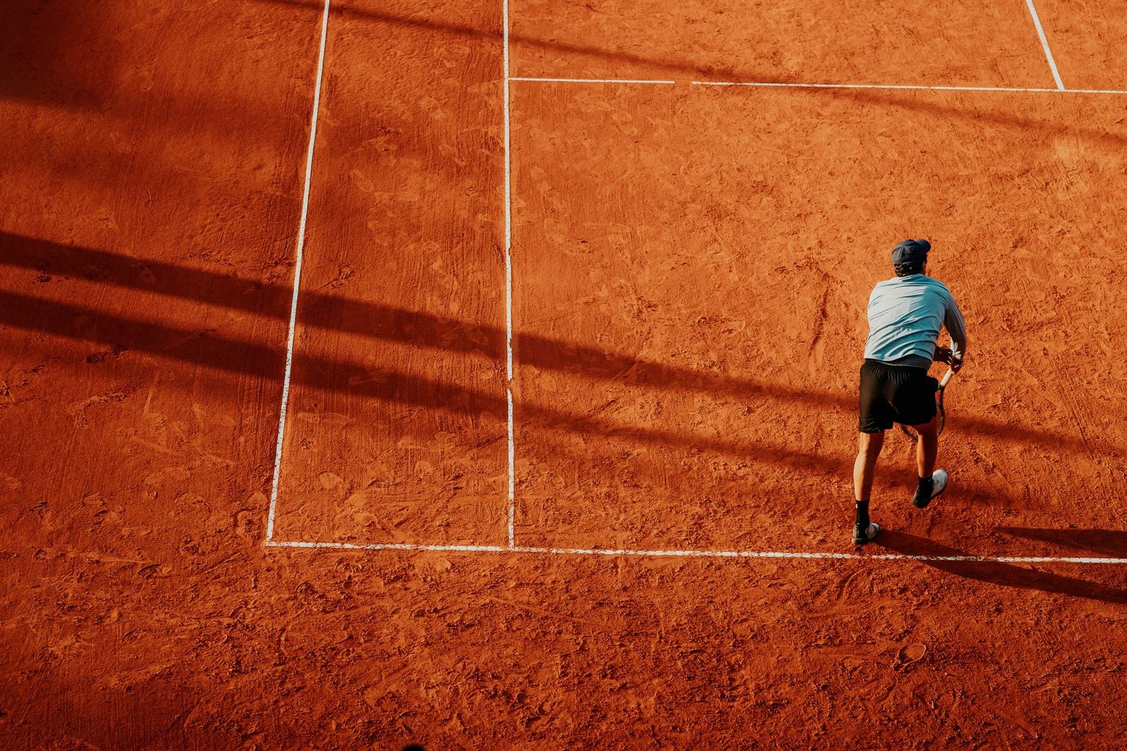 Aerial view of a tennis player in action on a clay court