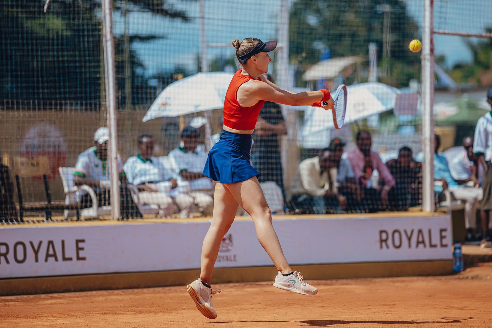 Player stretching into a volley during a competitive outdoor tennis match