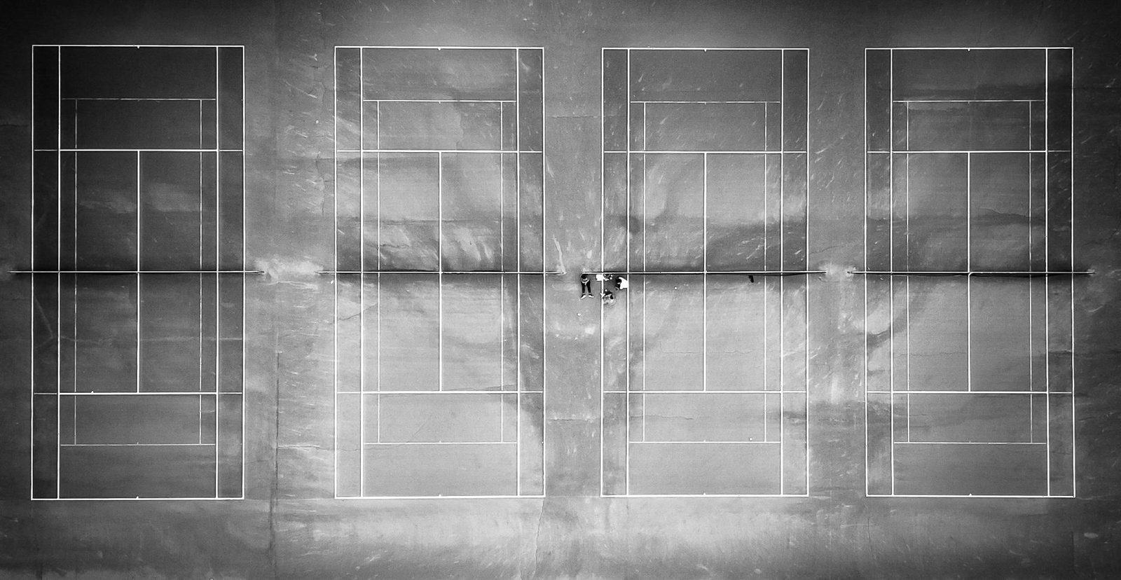 Monochrome aerial view of tennis courts with two players