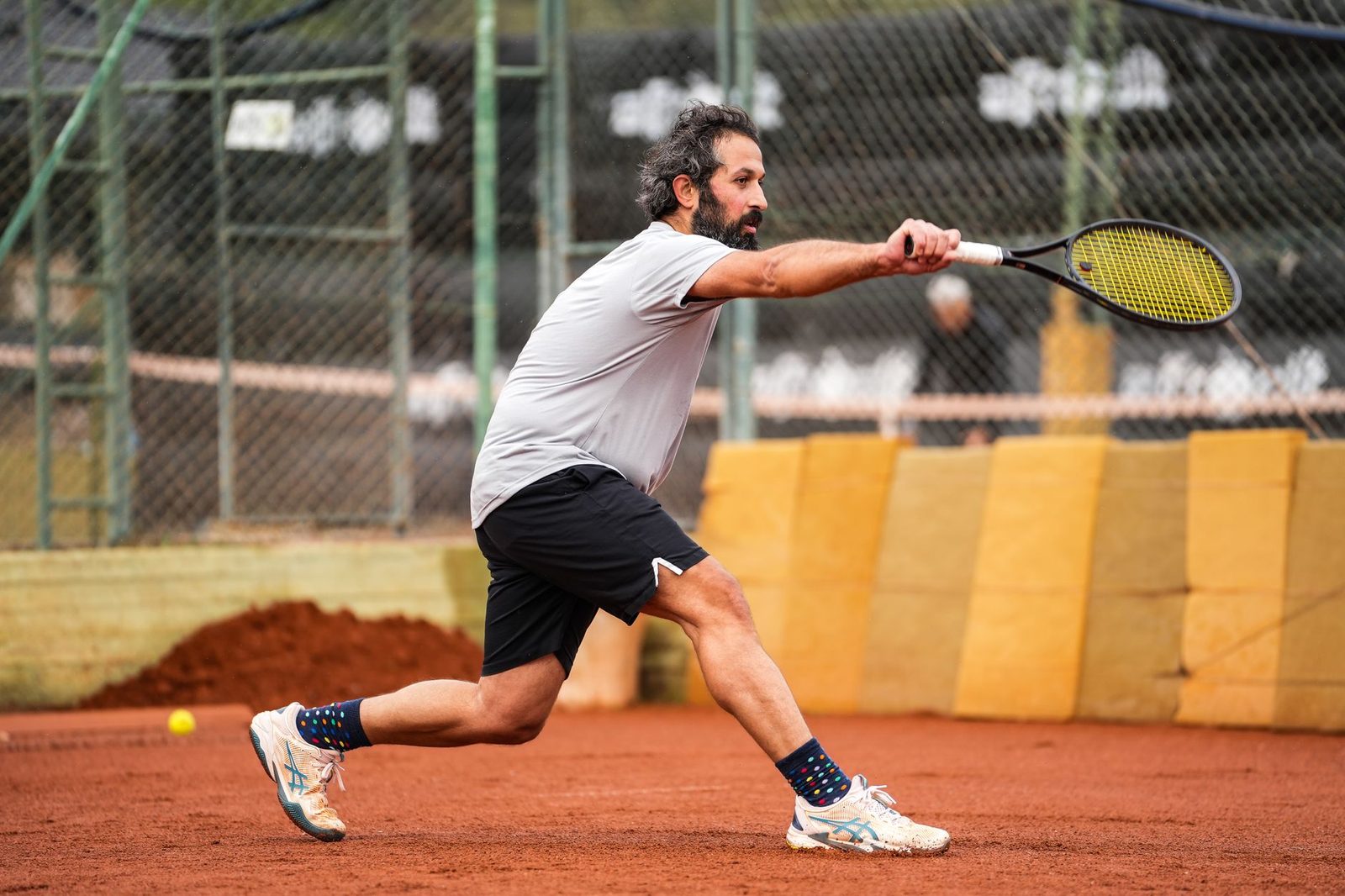 A tennis player in action on a clay court