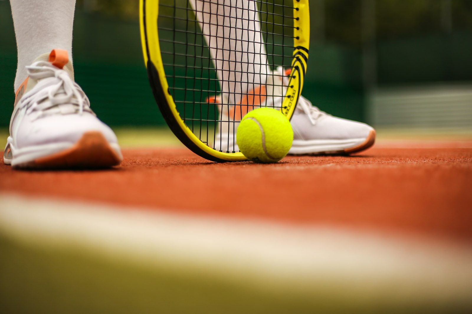 Player in tennis shoes mid-point during an on-court session