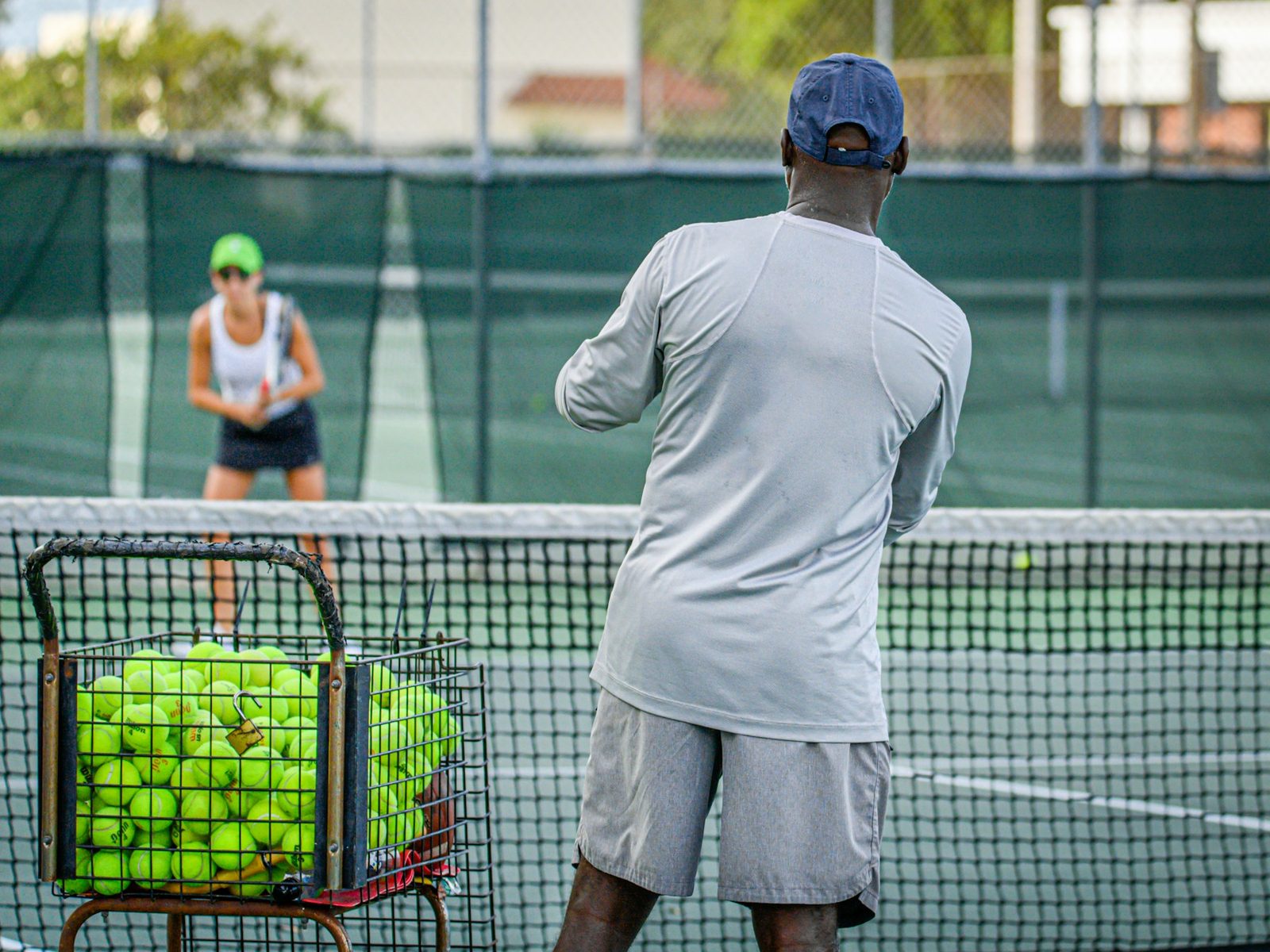 Two players rallying during a mixed doubles practice on an outdoor court