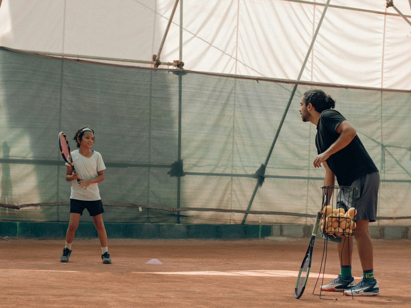 Two people playing tennis together on court