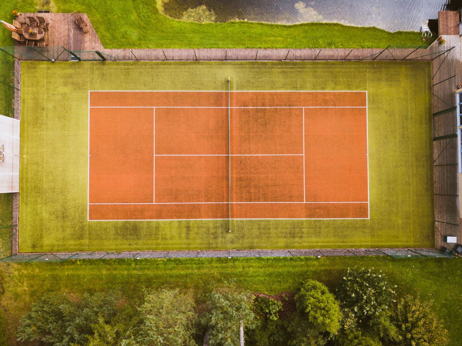 Aerial view of an empty tennis court showing all court markings