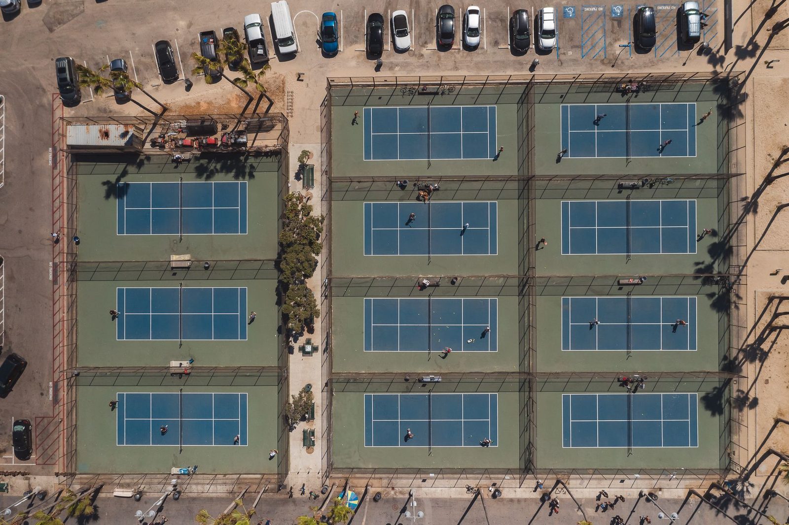 Aerial view of tennis courts showing the full doubles court width and the alleys