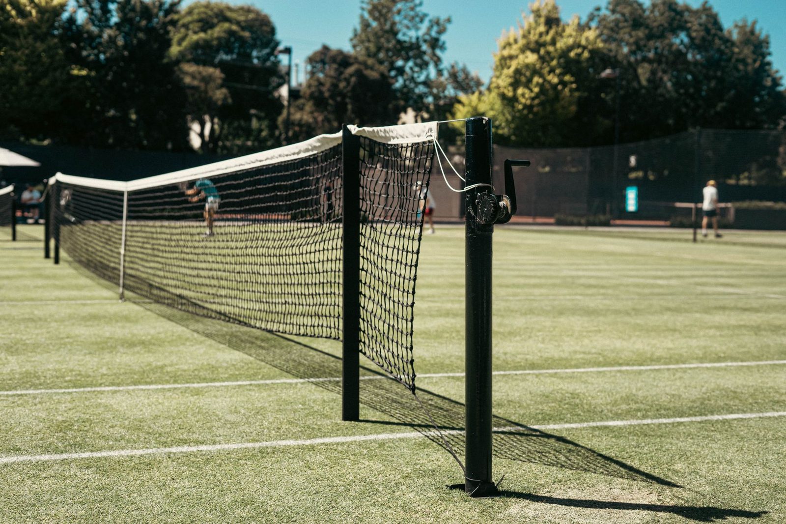 Close view of a tennis net at the centre strap, the area a doubles net player crosses when poaching