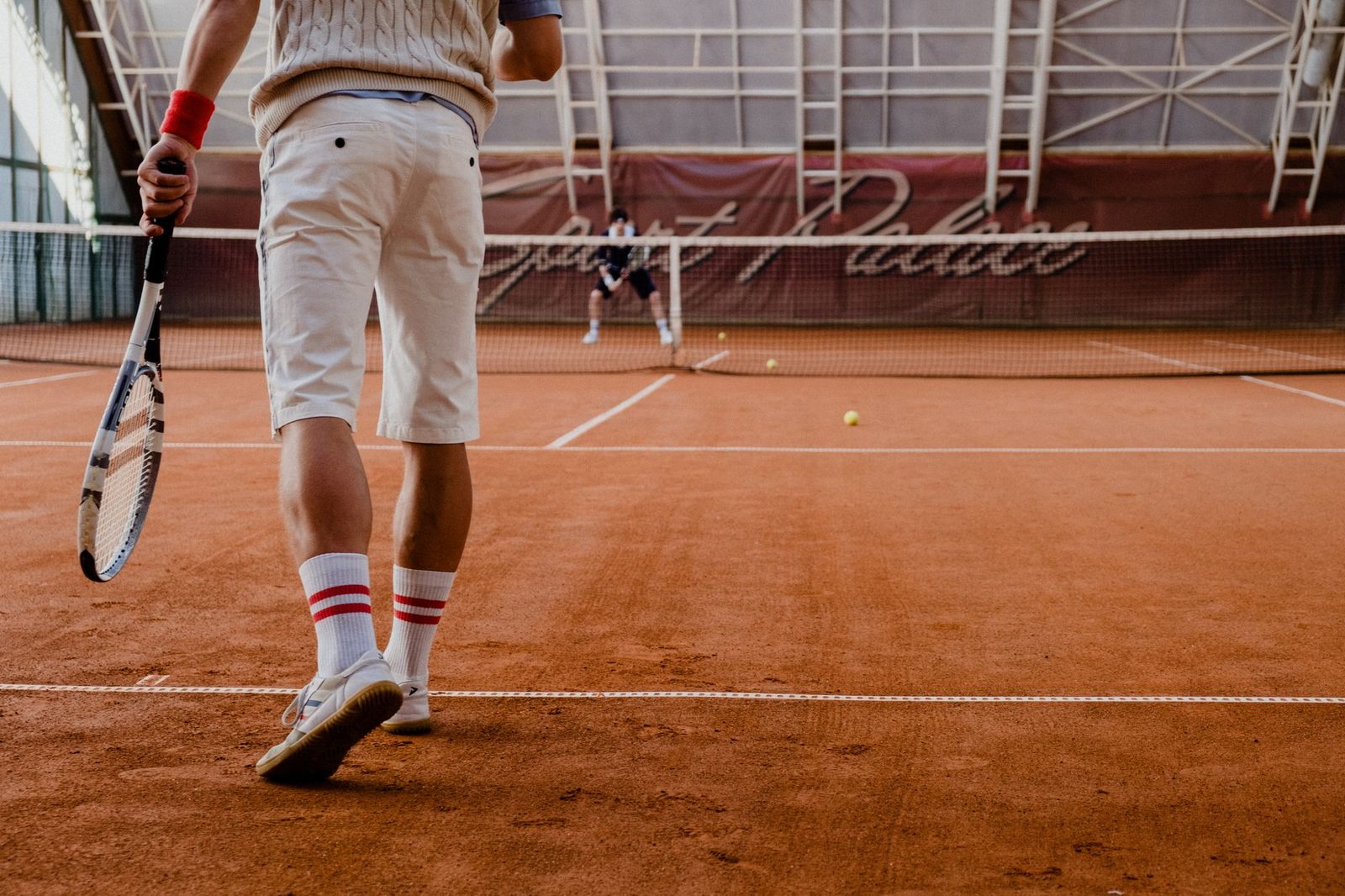 Players competing in a doubles point on an indoor clay court
