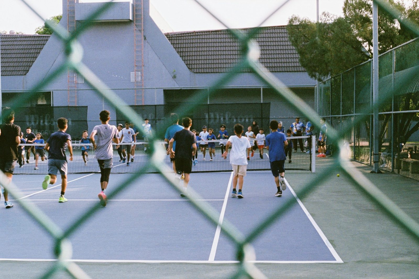 A group of people playing tennis together on an outdoor court