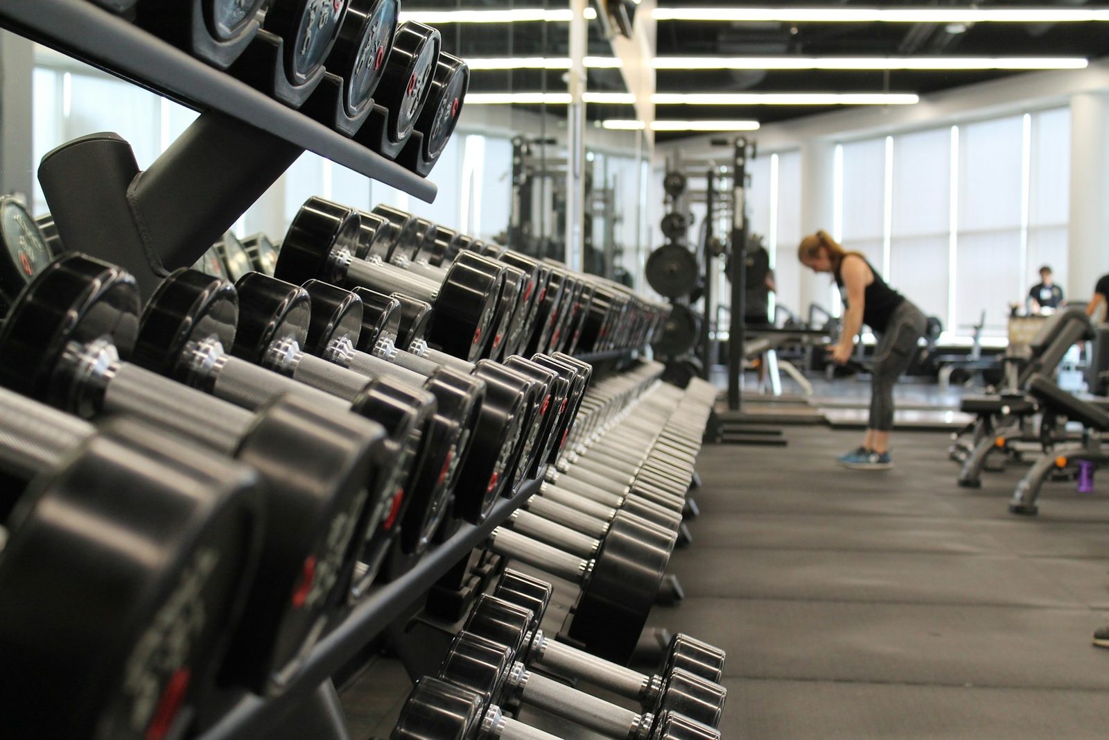 Woman standing surrounded by gym exercise equipment