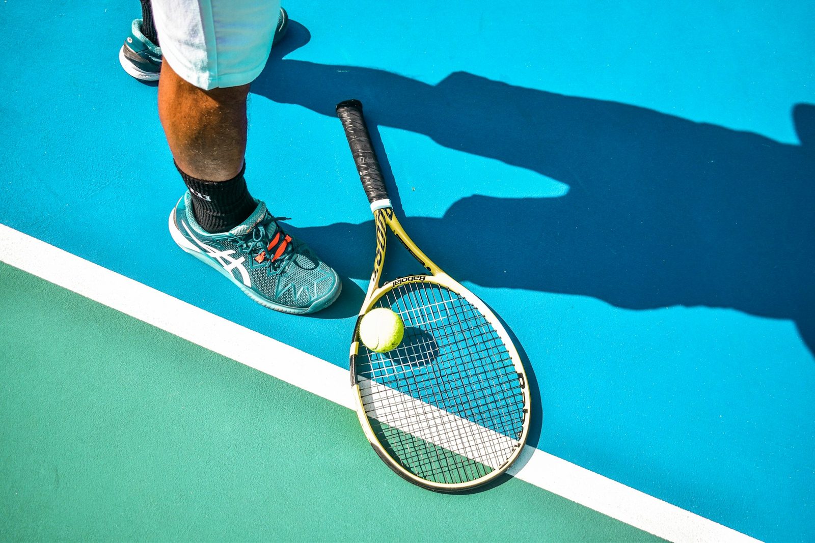 A person standing on a tennis court holding a racquet