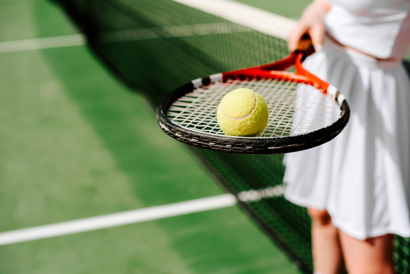Player holding a racquet and tennis ball, ready to begin a practice session