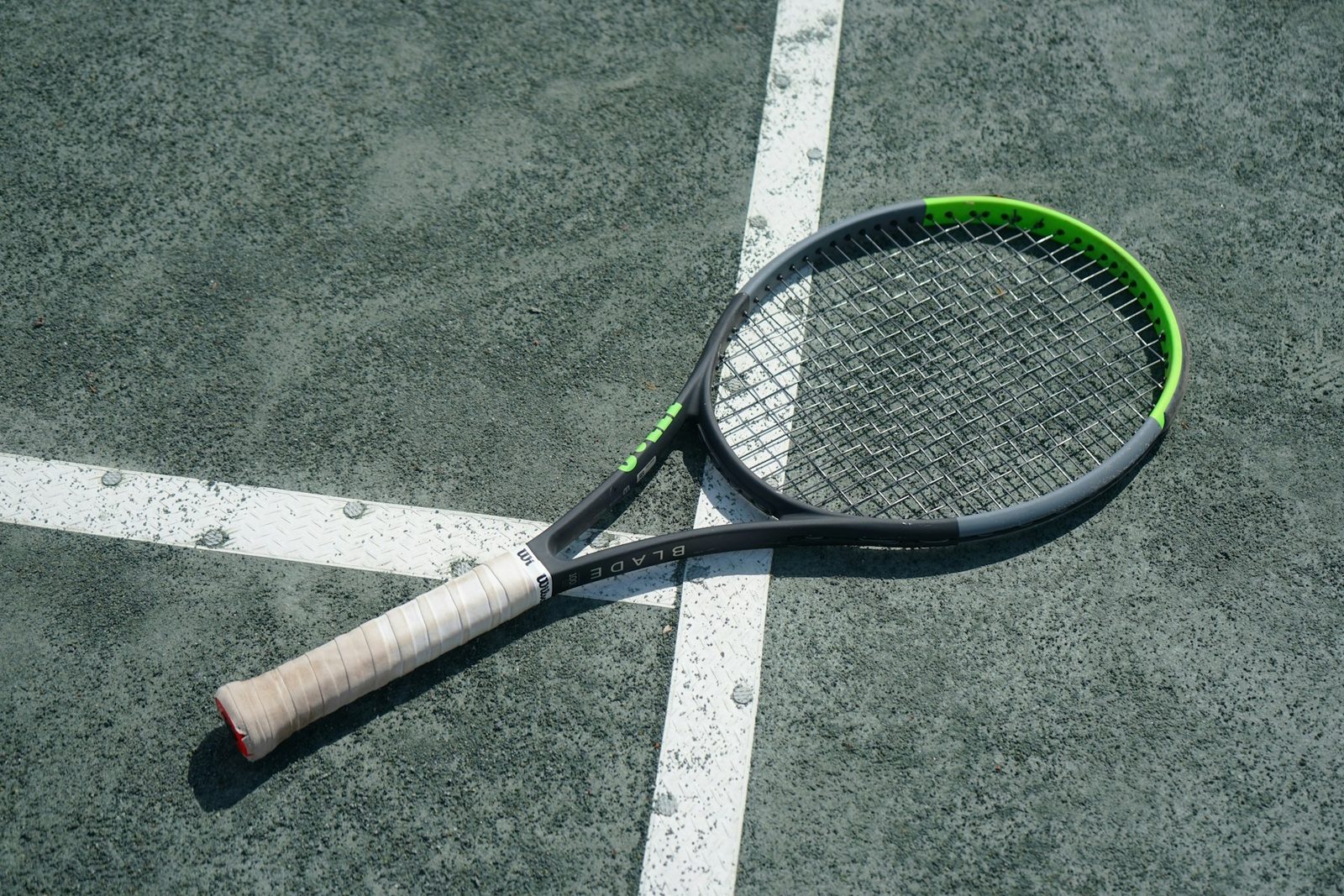 A tennis racquet laying on a tennis court