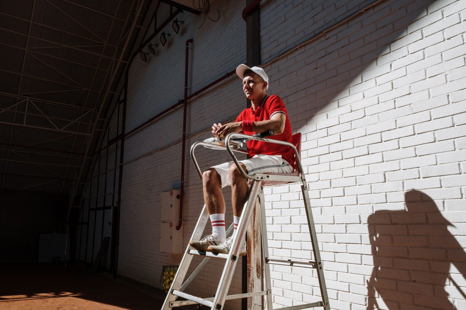 Tennis umpire seated on a high chair beside the court