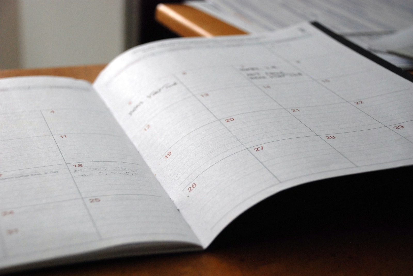 An open monthly planner on a wooden desk