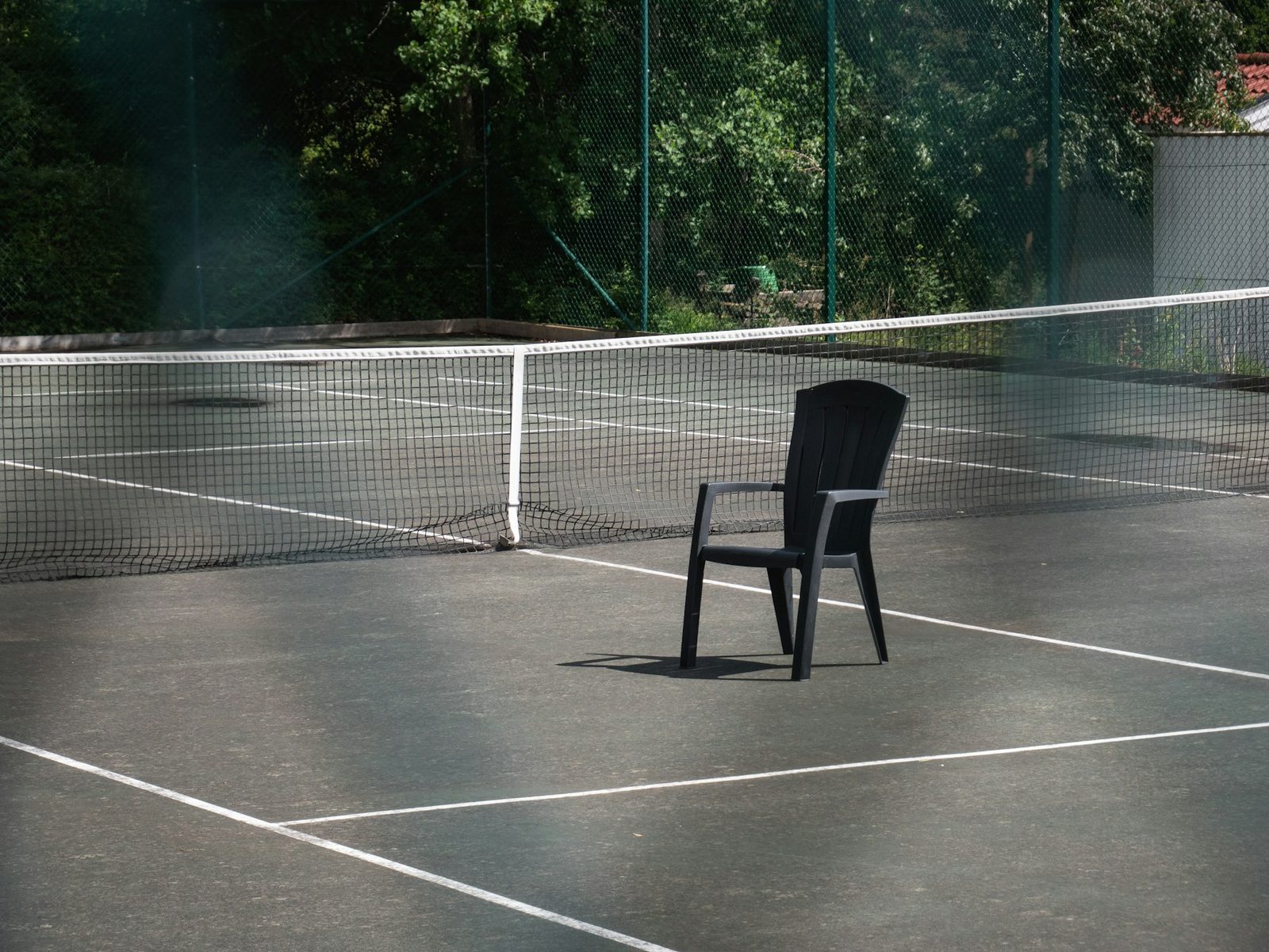 An umpire's chair beside a tennis court