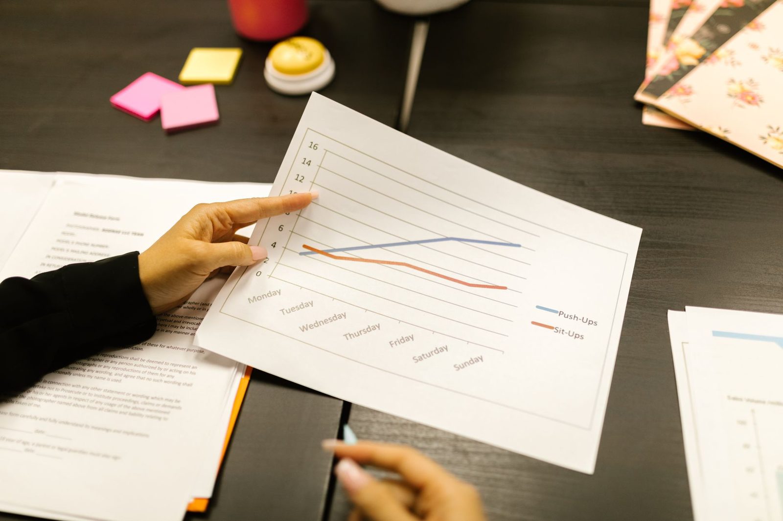 Hands reviewing a progress chart during a meeting