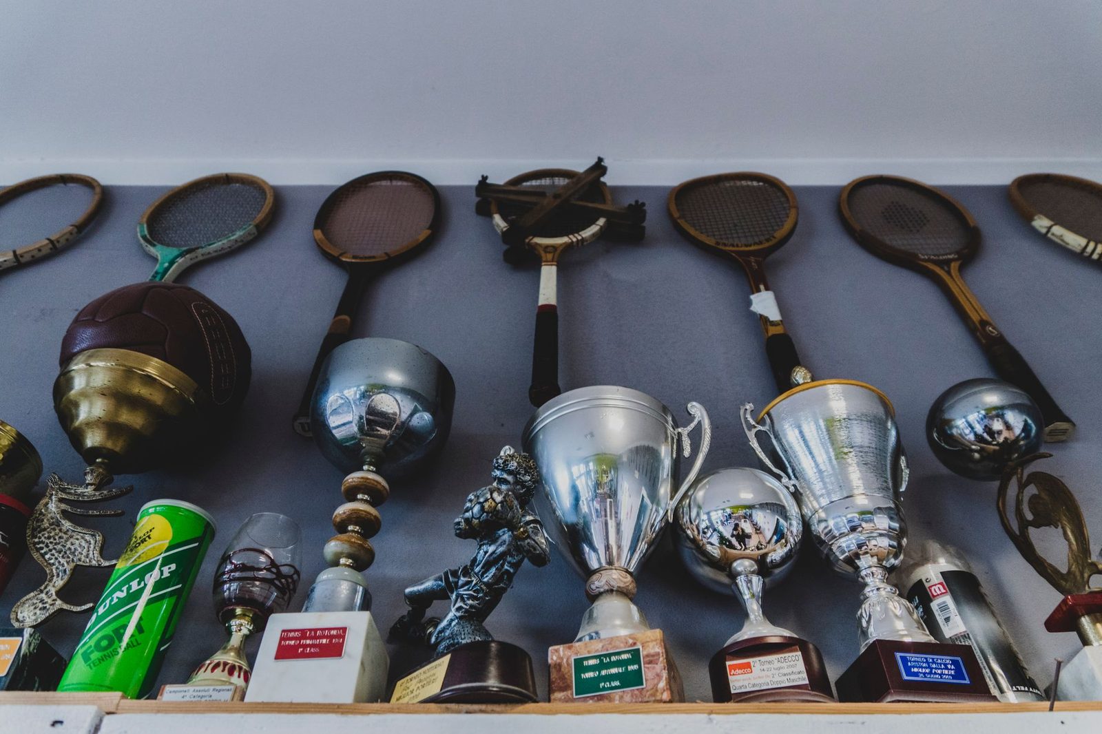 A collection of vintage sports equipment and trophies on a shelf