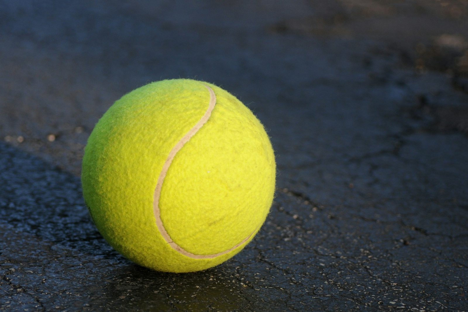 Close view of a single worn tennis ball